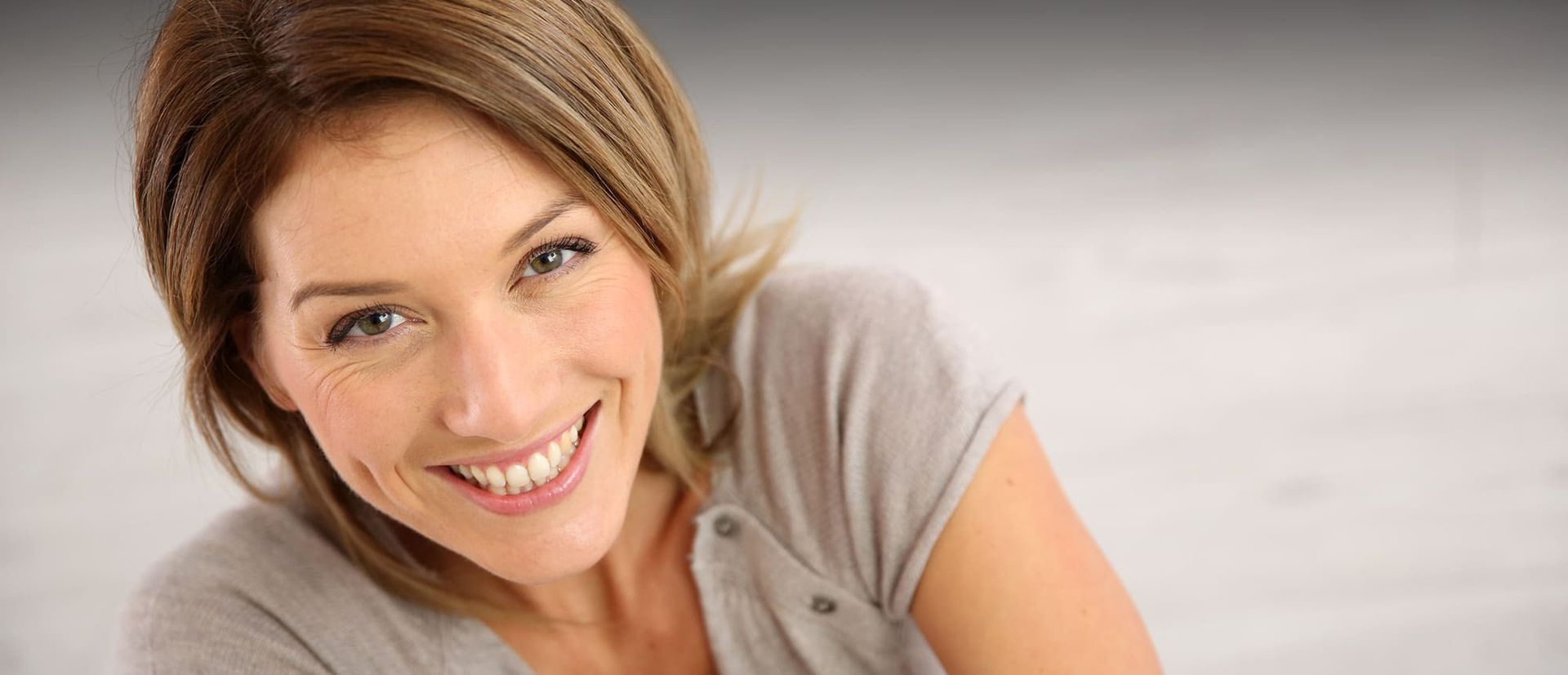 Frau schaut lächelnd in die Kamera